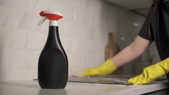 Housewife in Yellow Gloves Washes Spraying and Wipes Electric Stove at Kitchen