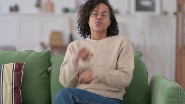 Worried Young African Woman with Laptop Thinking on Sofa