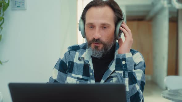 Adult Man on Conference Call From Coworking Cafe