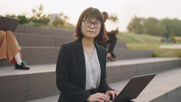 Portrait of Asian Businesswoman with Laptop in Park