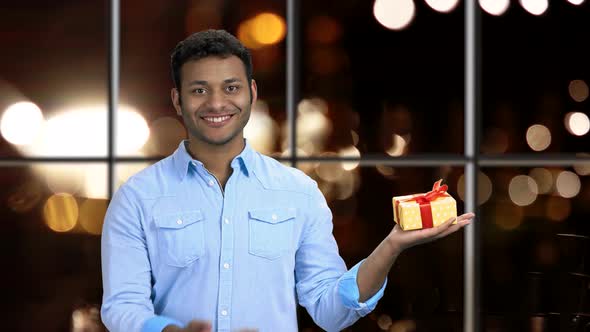 Smiling Man Pointing at Gift Box in His Hand.