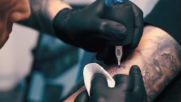 Male Tattoo Artist Tattooing a Client