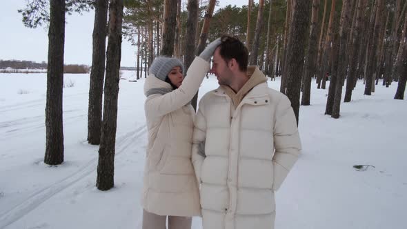Beautiful Couple on a Walk in the Winter Forest