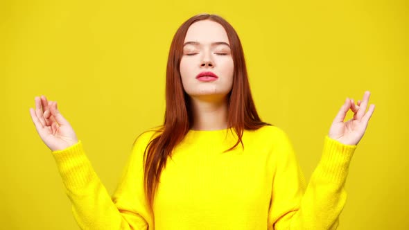 Middle Shot of Slim Cute Redhead Woman Meditating at Yellow Background