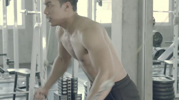 Young asian man doing cable rope triceps pull up exercise for bodybuilding in the gym.