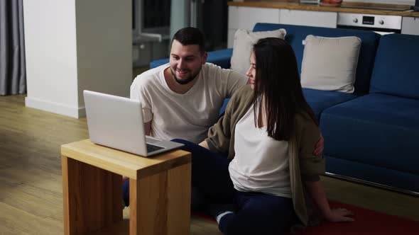 Pregnant Woman and Man Talking By Video Call Using Laptop