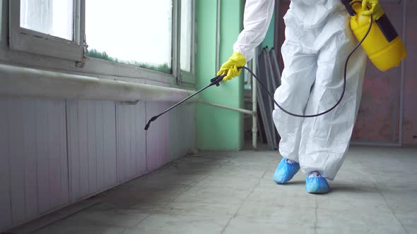 Exterminator in Overalls Carries Out Processing of the Room From a Mold