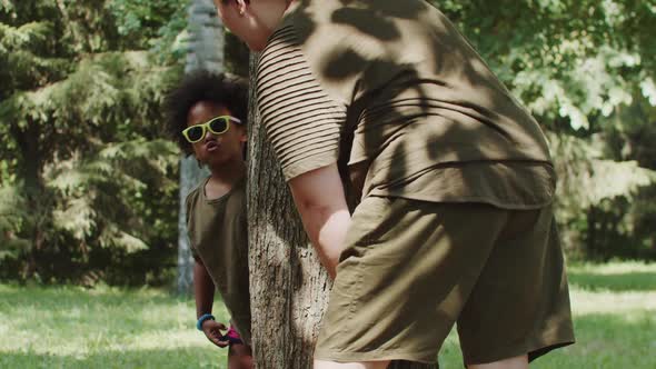 Little Black Girl and Her Mother Playing in the Park  Look Out From Behind a Tree