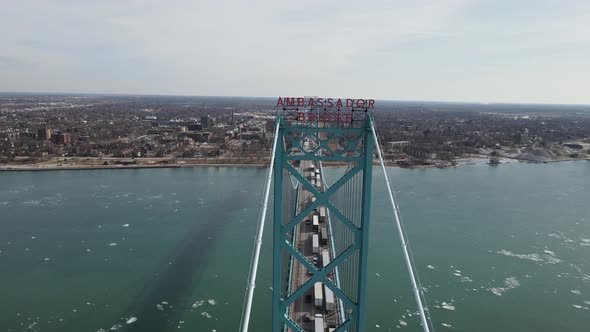 Ambassador bridge sign and endless line of semi-trucks piling on it, aerial view