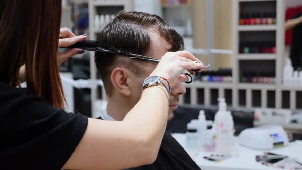 Man Hair Cut By Hands Of Professional Woman Hairdresser In Barbershop