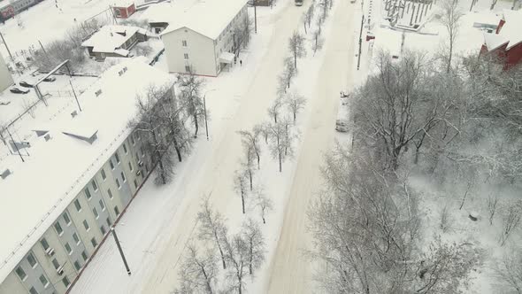 Few Cars on a City Road Covered with Thick White Snow After a Blizzard