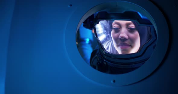 Female Astronaut Looking Out of Spaceship Porthole