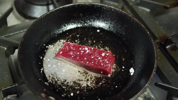 Raw Tuna Steaks Served on Metal Frying Pan with Lime Chili Oil Salt Coriander Leaves and Lemongrass