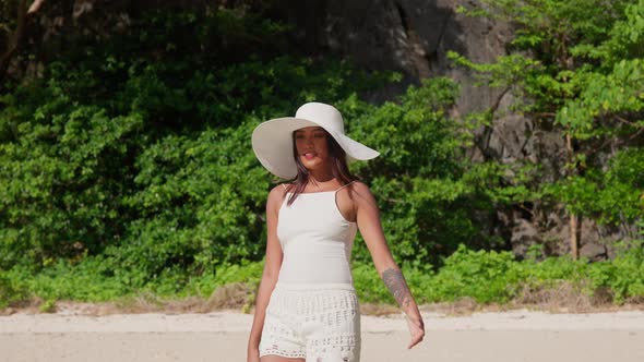 Smiling Woman In Sun Hat Walking Along Hidden Beach