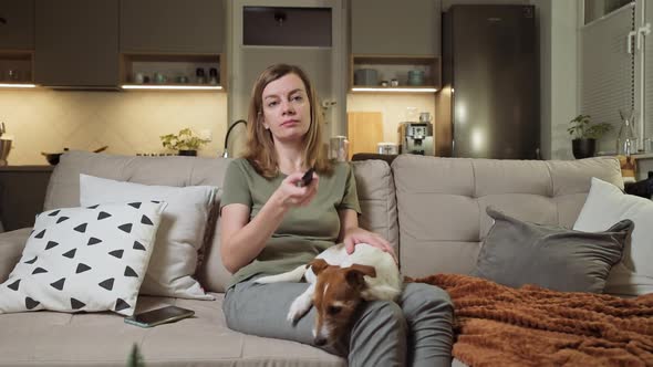 Woman Watching TV on Coach with Dog