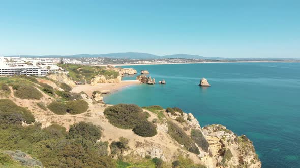 Rugged Coastline steep cliffs bordering Dona Ana beach in Lagos, Algarve, Portugal