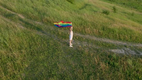 Woman lesbian with LGBT flag on a green montains