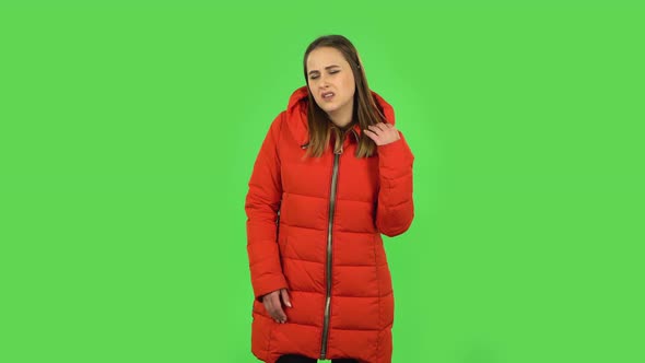 Lovely Girl in a Red Down Jacket Is Upset and Tired. Green Screen