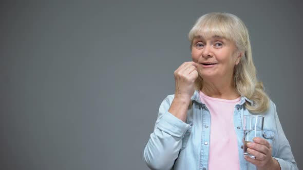 Cheerful Elderly Lady Taking Antiviral Pill, Immunity Strengthening, Healthcare