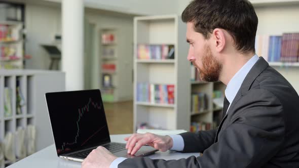 Focused Successful Trade Broker Uses Laptop to Analyze Financial Cryptocurrency Market Invest in