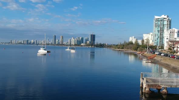 Aerial view of a beach side town with a city skyline in the distance