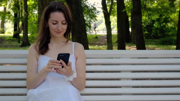 Beautiful young woman is typing a message in a smartphone