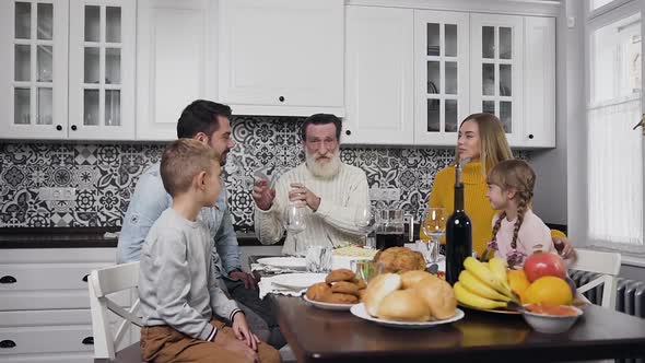 Happy Smiling Family with Children and Grandfather Gethering Together Around Festive Table