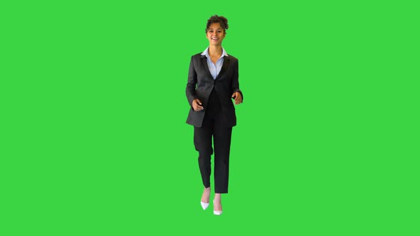 Young Curly African Girl in a Suit Walking and Talking on Camera on a Green Screen Chroma Key