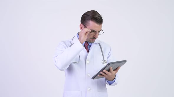 Young Happy Hispanic Man Doctor Using Digital Tablet