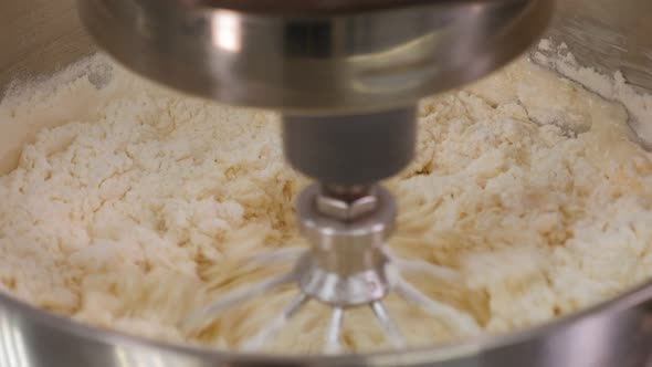 Close-up of a Food Processor Whipping Dough Ingredients in a Bowl.