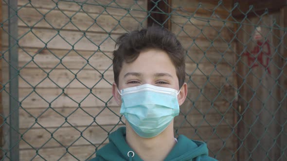 Portrait of a joyful laughing young man in a hygienic protective medical mask