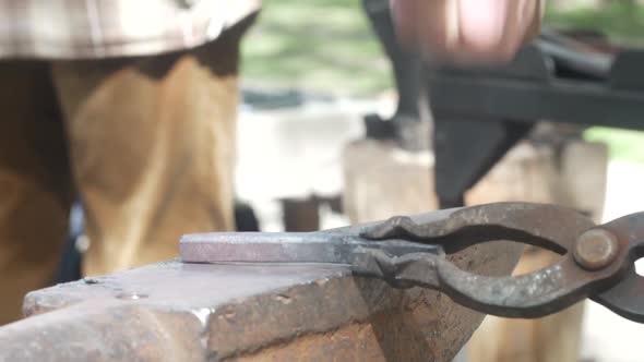 Blacksmith Forges Metal On Anvil