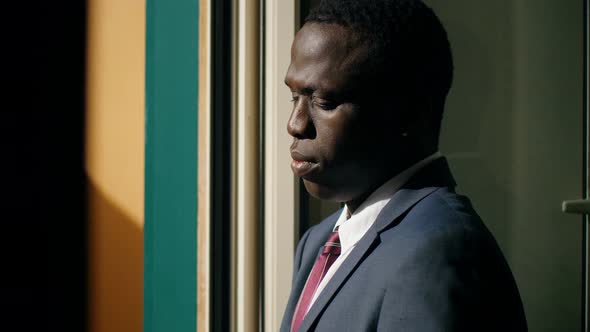 Depressed and Sad African American Businessman at The Window