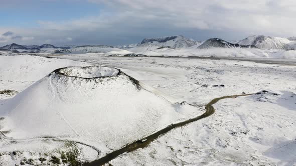 Aerial of Road with Driving Car on Side of the Snow Covered Volcano in Iceland