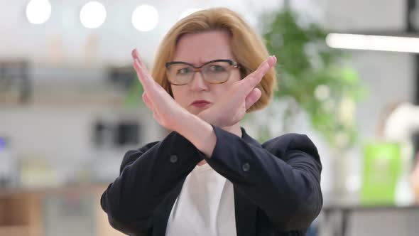 Portrait of Old Businesswoman Saying No By Arm Gesture