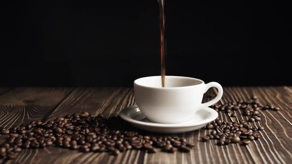 Coffee Cup and Coffee Beans. White Cup of Evaporating Coffee on the Table with Roasted Bean. Slow