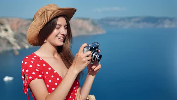 Happy Travel Glamour Female in Hat Taking Photo of Nature Seascape Using Camera Medium Closeup