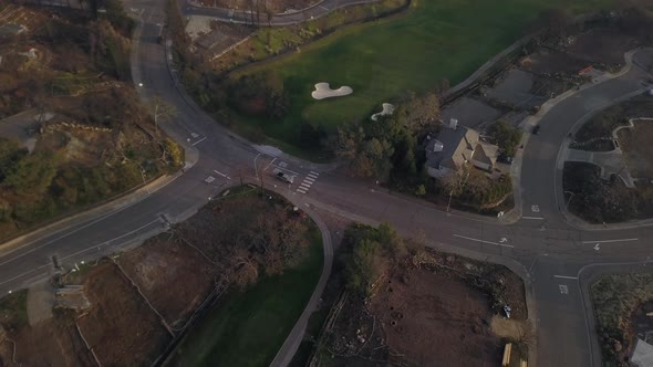 Drone fly over of burnt out neighborhood next to golf course that is rebuilding after wildfires