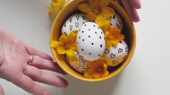 Yellow Cup on a White Background with Easter Eggs. Female Hands Move the Cup with the Eggs on the