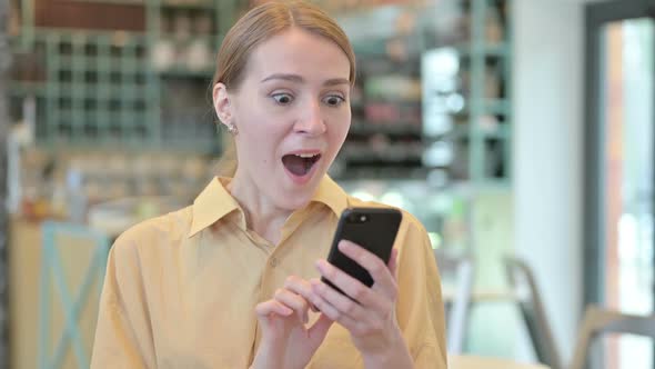 Portrait of Young Woman Celebrating Success on Phone