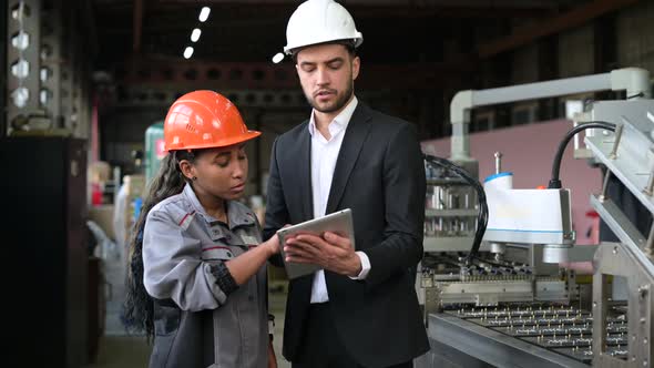 A young leader of the conveyor belt discusses work processes with a female worker