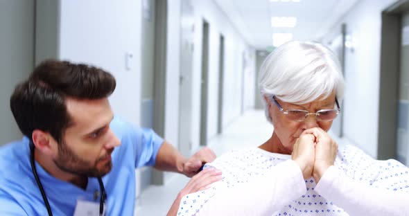 Nurse consoling stressed female senior patient