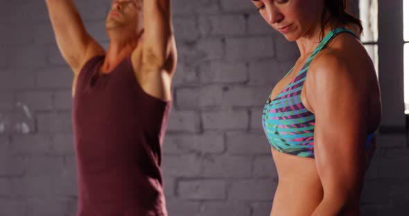 Woman and man exercising with dumbbell and kettlebell