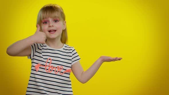 Funny Child Girl Showing Thumbs Up and Pointing Empty Place Advertising Area for Commercial Text