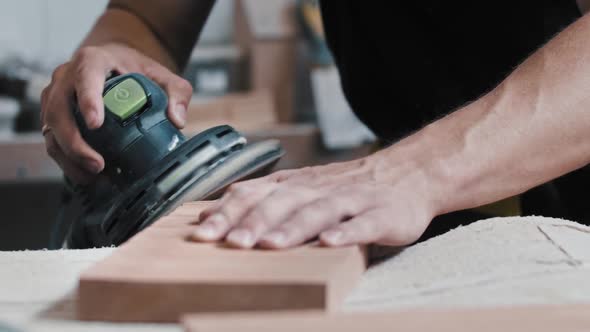 The Worker Grinding Tne Angle and the Side of a Wooden Detail on the Table