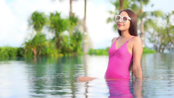 Young asian woman enjoy around outdoor swimming pool for leisure