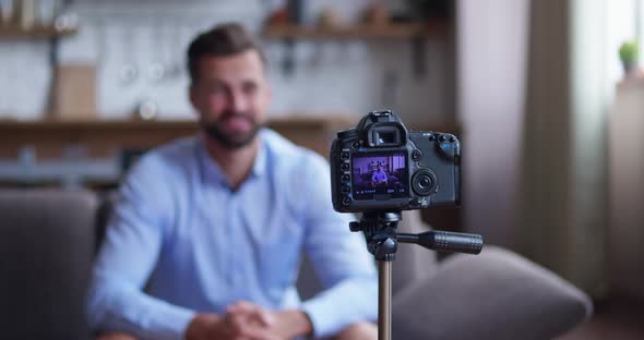 Blurred Silhouette of a Man Videoblogger Filming New Vlog Video with Professional Camera Siting Cozy