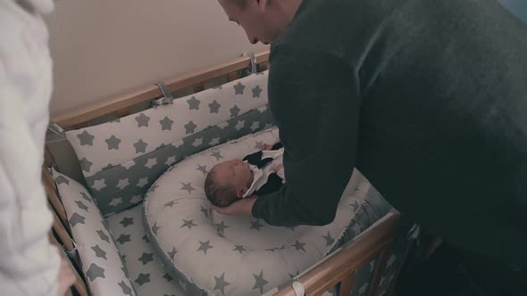 Careful Daddy Puts Sleeping Baby in Crib and Sister at Home