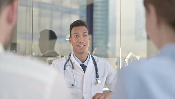 Rear Back View of Couple Having Talk with Young Doctor