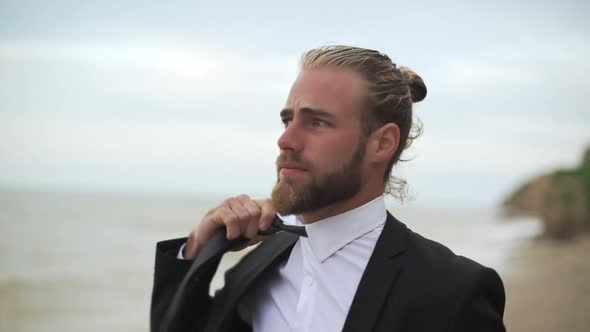 Tired Businessman in Black Suit Loosening Tie Enjoying Resting Near Seaside After Busy Day Slomo